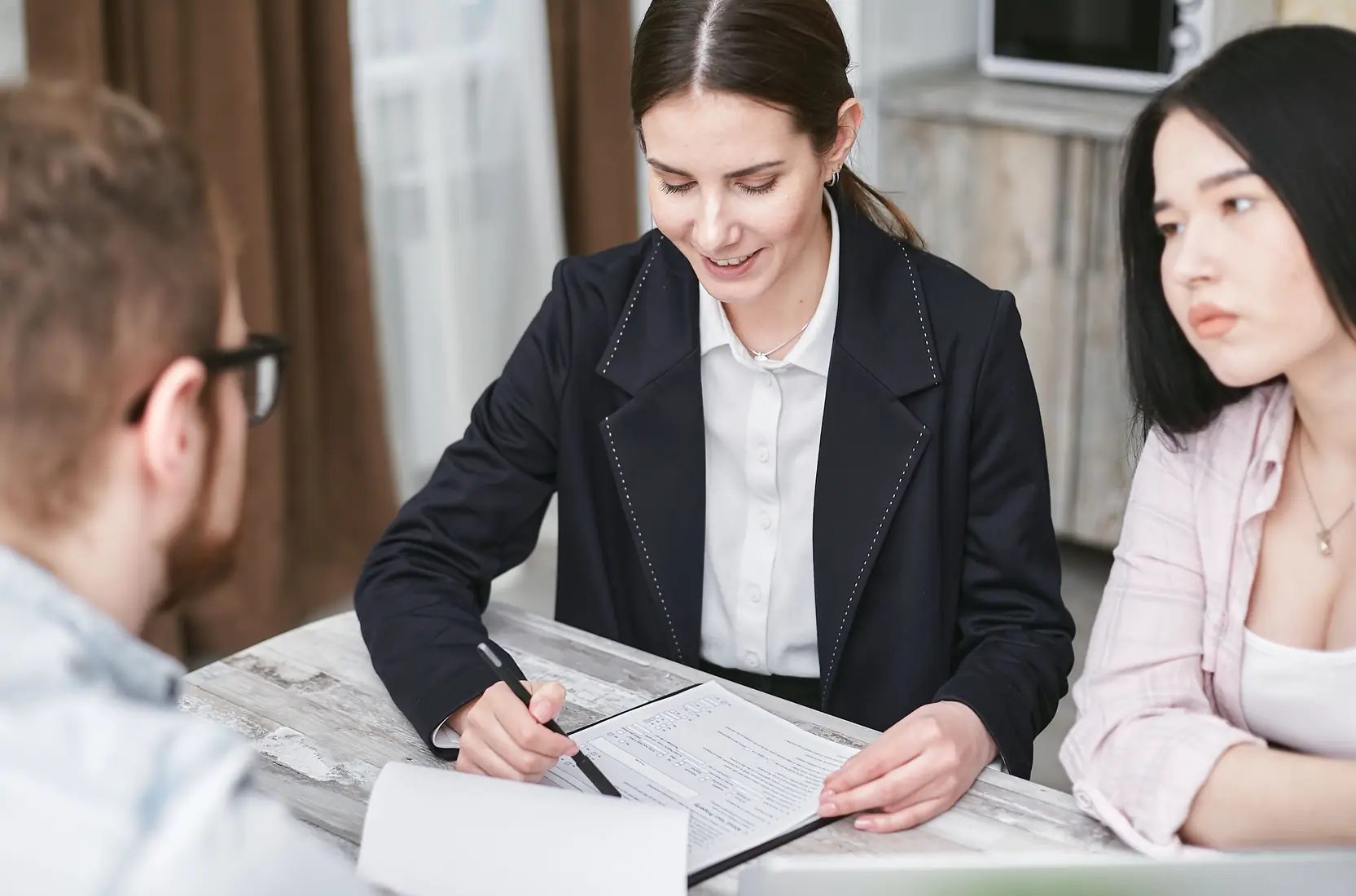 Accountant walking two clients through their paperwork at a table
