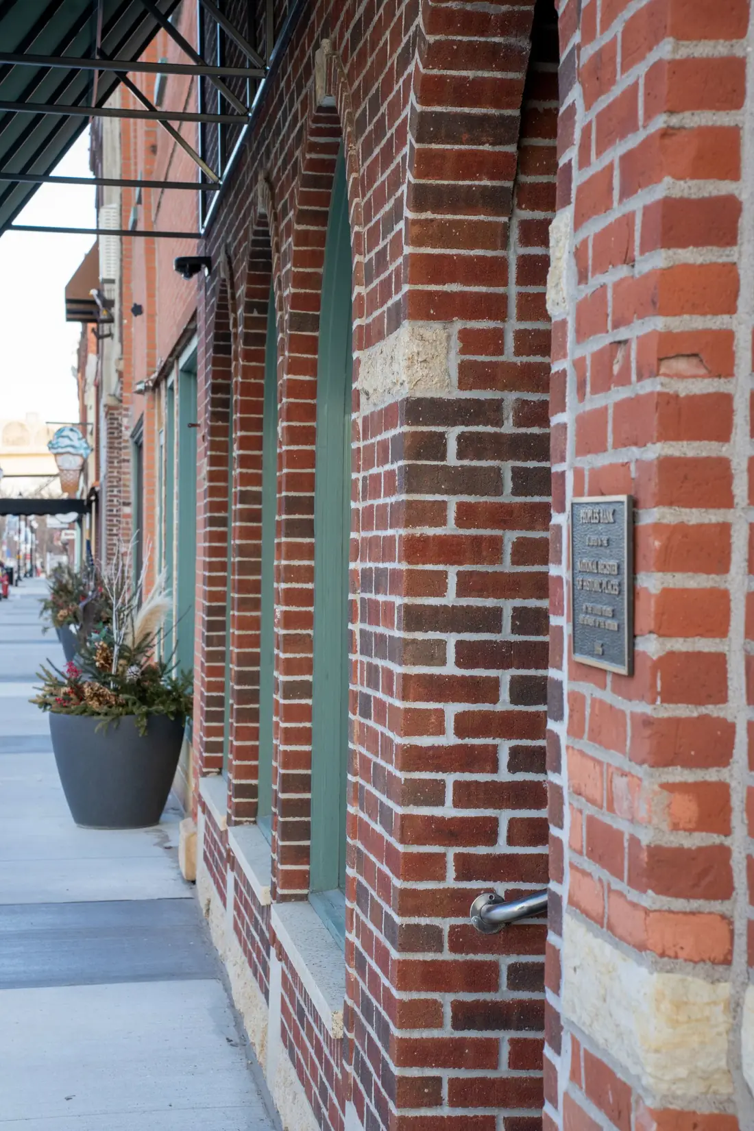 Brick storefront arches along a quiet sidewalk