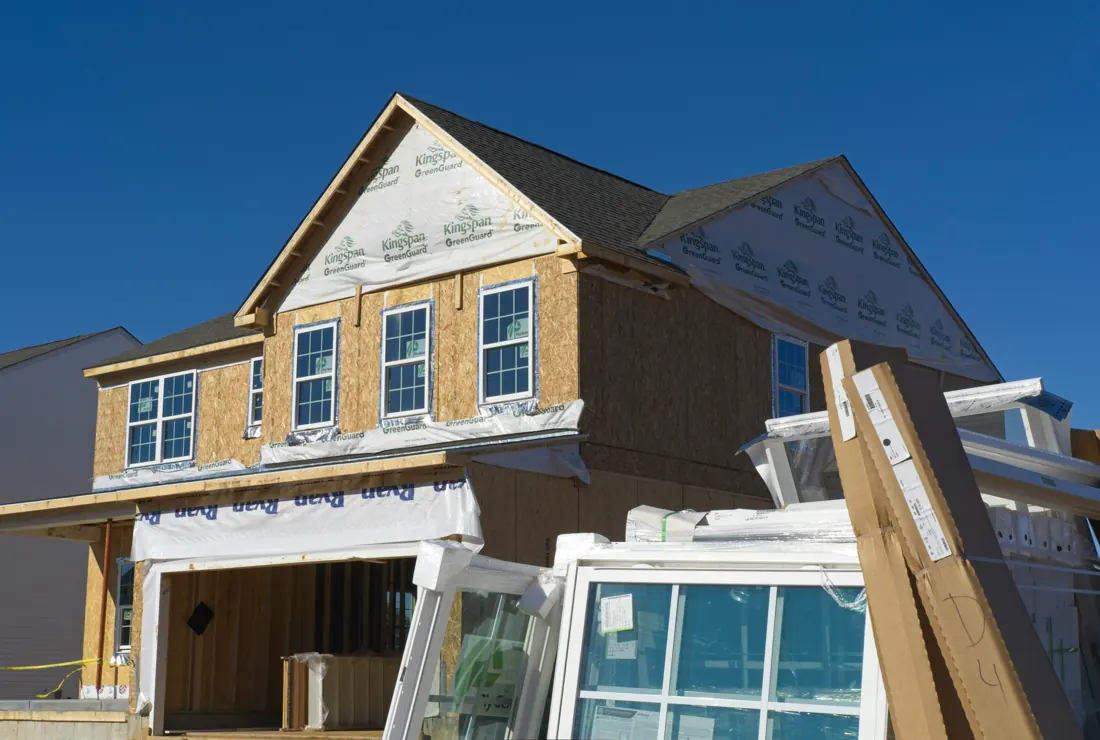 New house going up, sheathed walls and roof with windows waiting to be installed