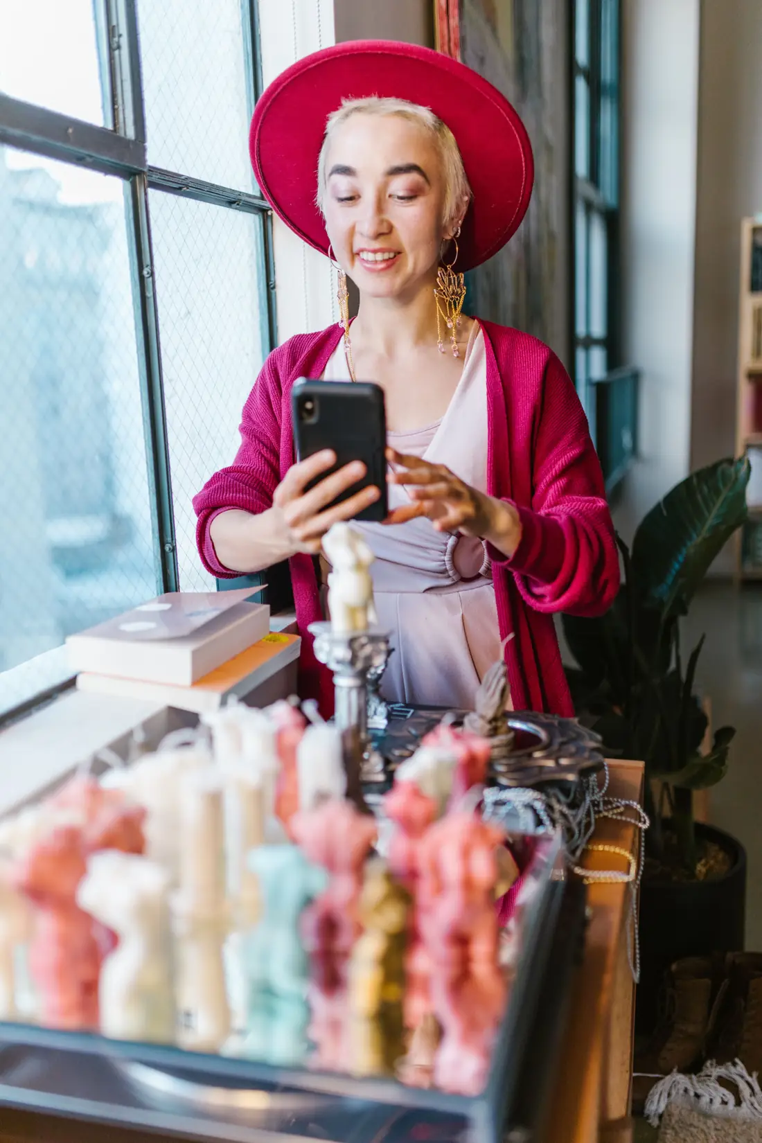 Small-business owner photographing her handmade candles with a phone