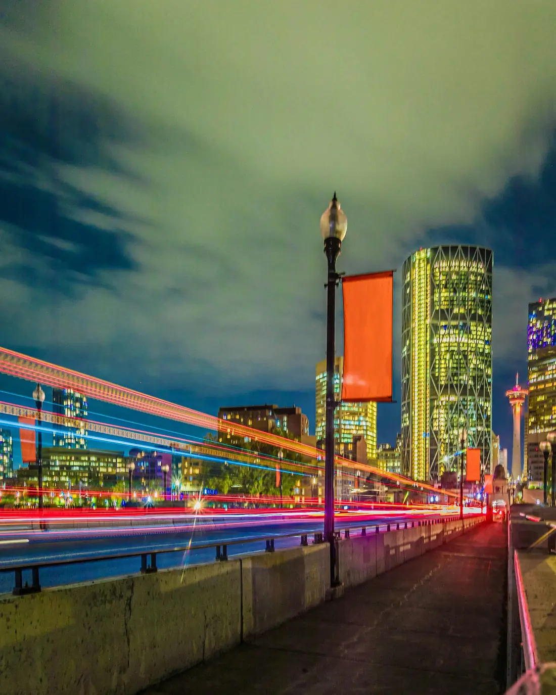 Traffic light trails beside downtown office towers at night