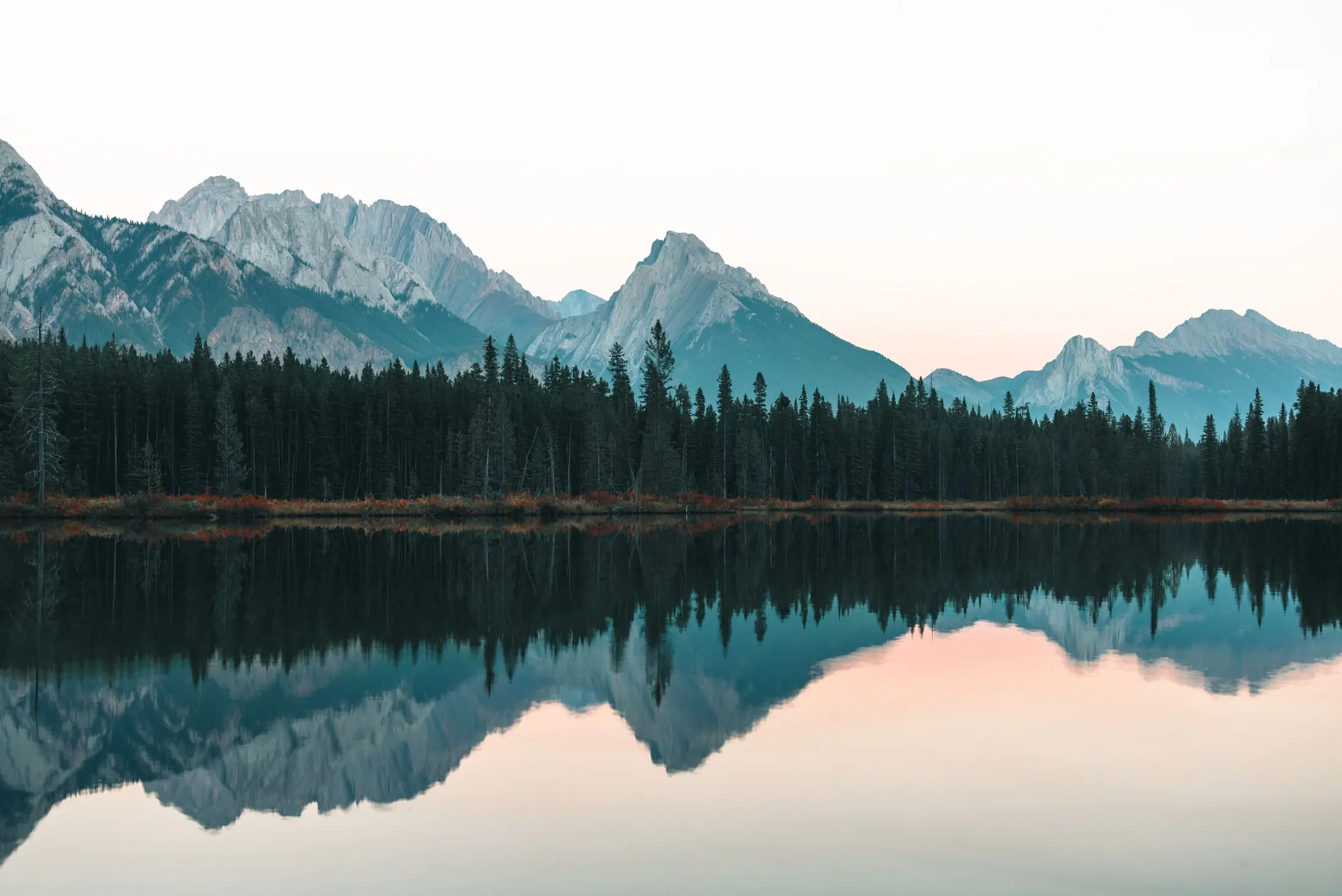 Snow-dusted mountain range reflected in a still lake